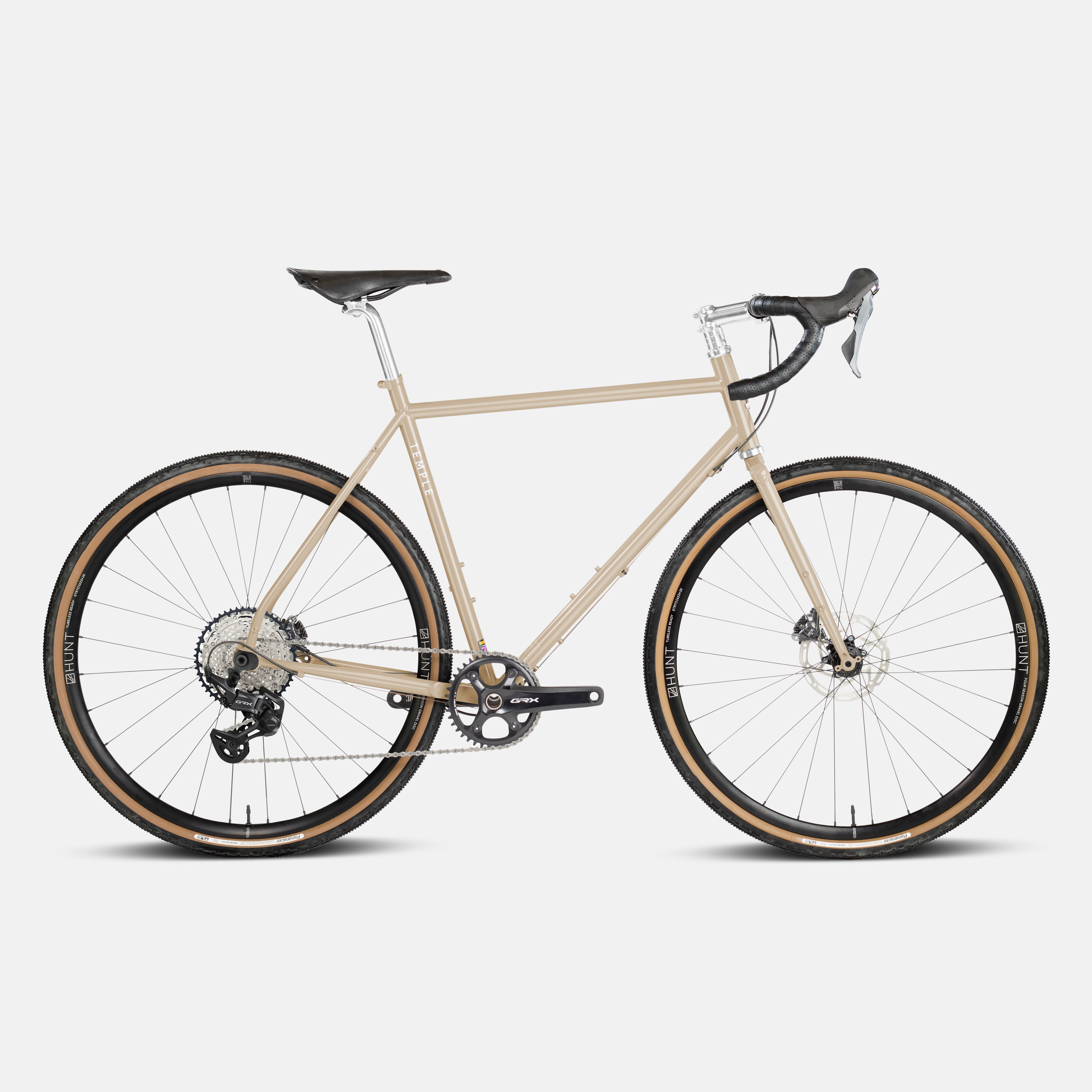 Lightweight steel gravel bike, sand colour in a studio setting.