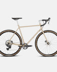 Lightweight steel gravel bike, sand colour in a studio setting.