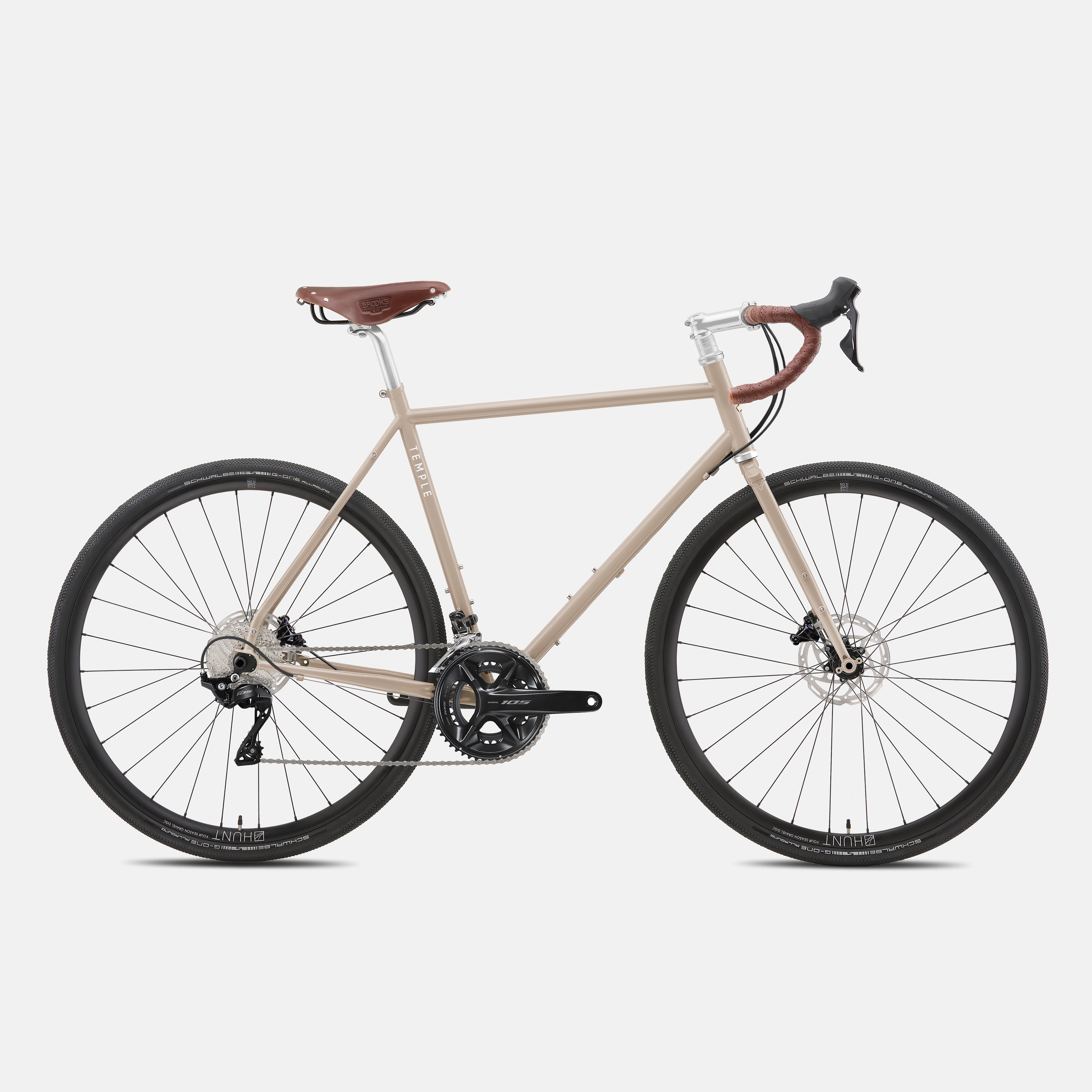 Beige lightweight steel adventure bike in a studio setting.