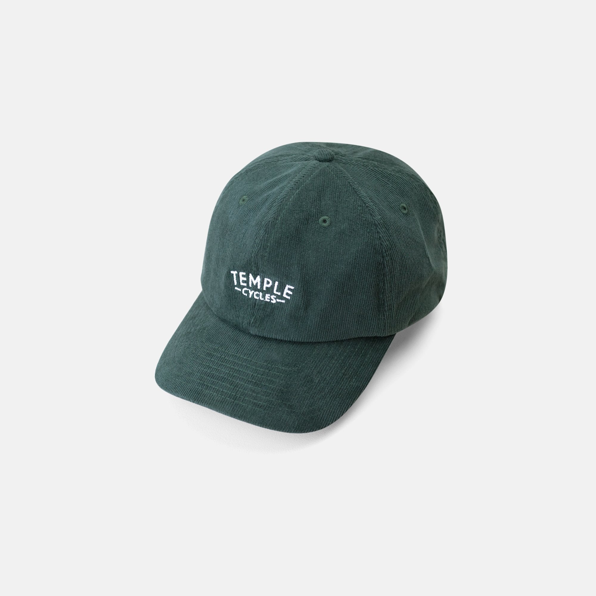 Temple corduroy cap made from 100% premium organic cotton in dark green, studio setting.