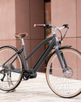 Gloss black Step Through women’s electric bike, urban setting. 