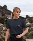 Women’s sustainable graphic tee, navy colour, beach setting.