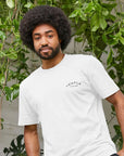 Subtle white graphic tee on a male model, urban setting. 