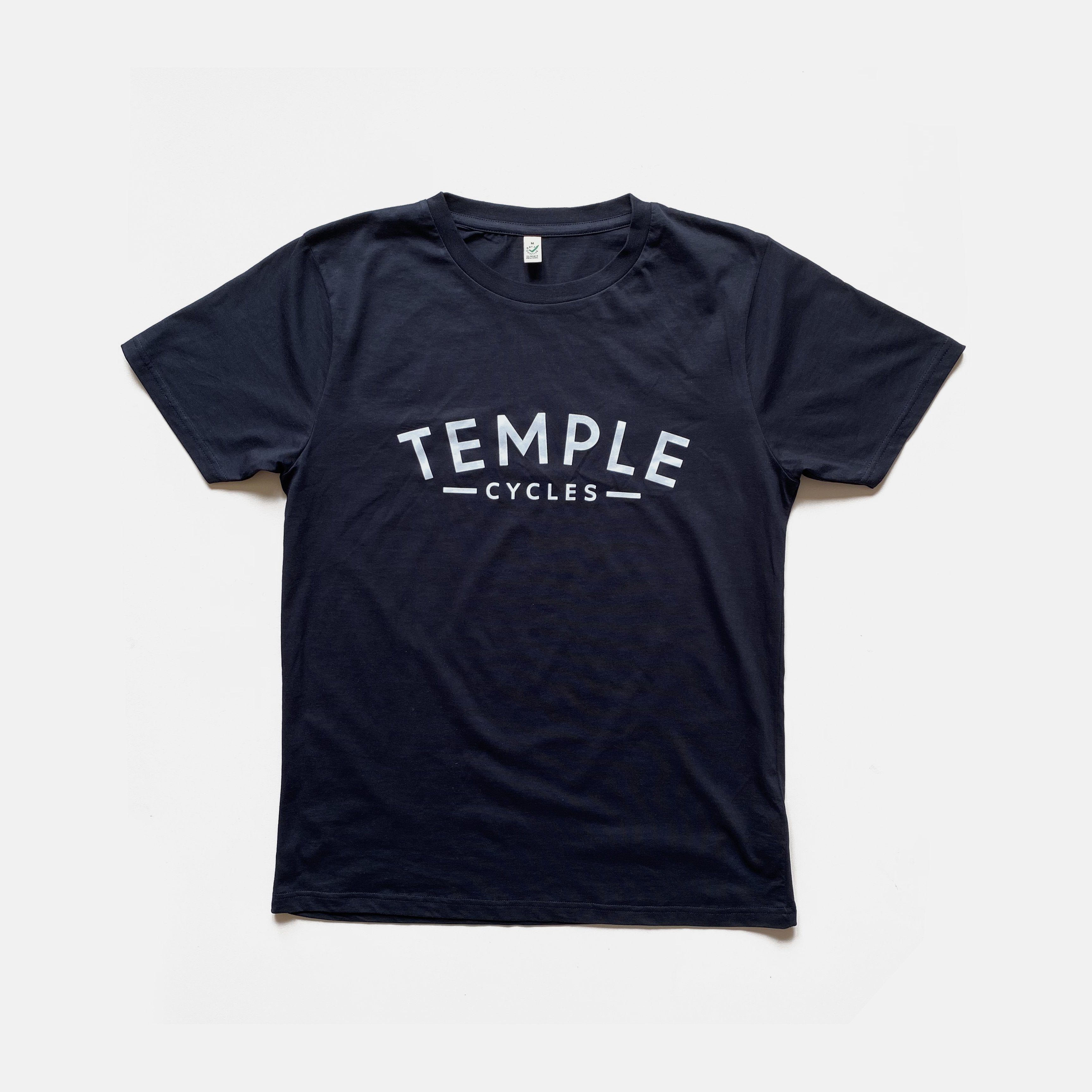 Fair Trade, men’s super soft Temple logo tee, front view, navy, studio setting.