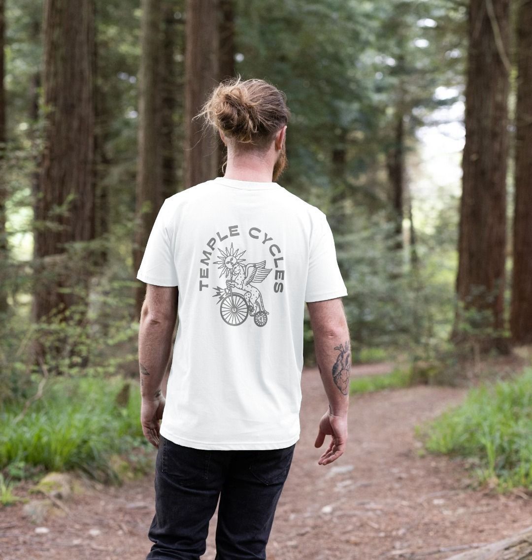 Men’s white graphic tee on model in forest setting.