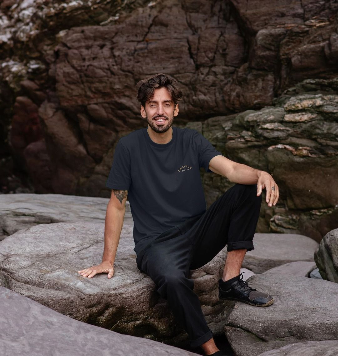 Clara unisex super soft navy T Shirt on male model, beach setting. 