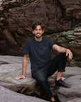 Clara unisex super soft navy T Shirt on male model, beach setting. 