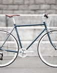 Classic lightweight blue commuting bike, urban setting.