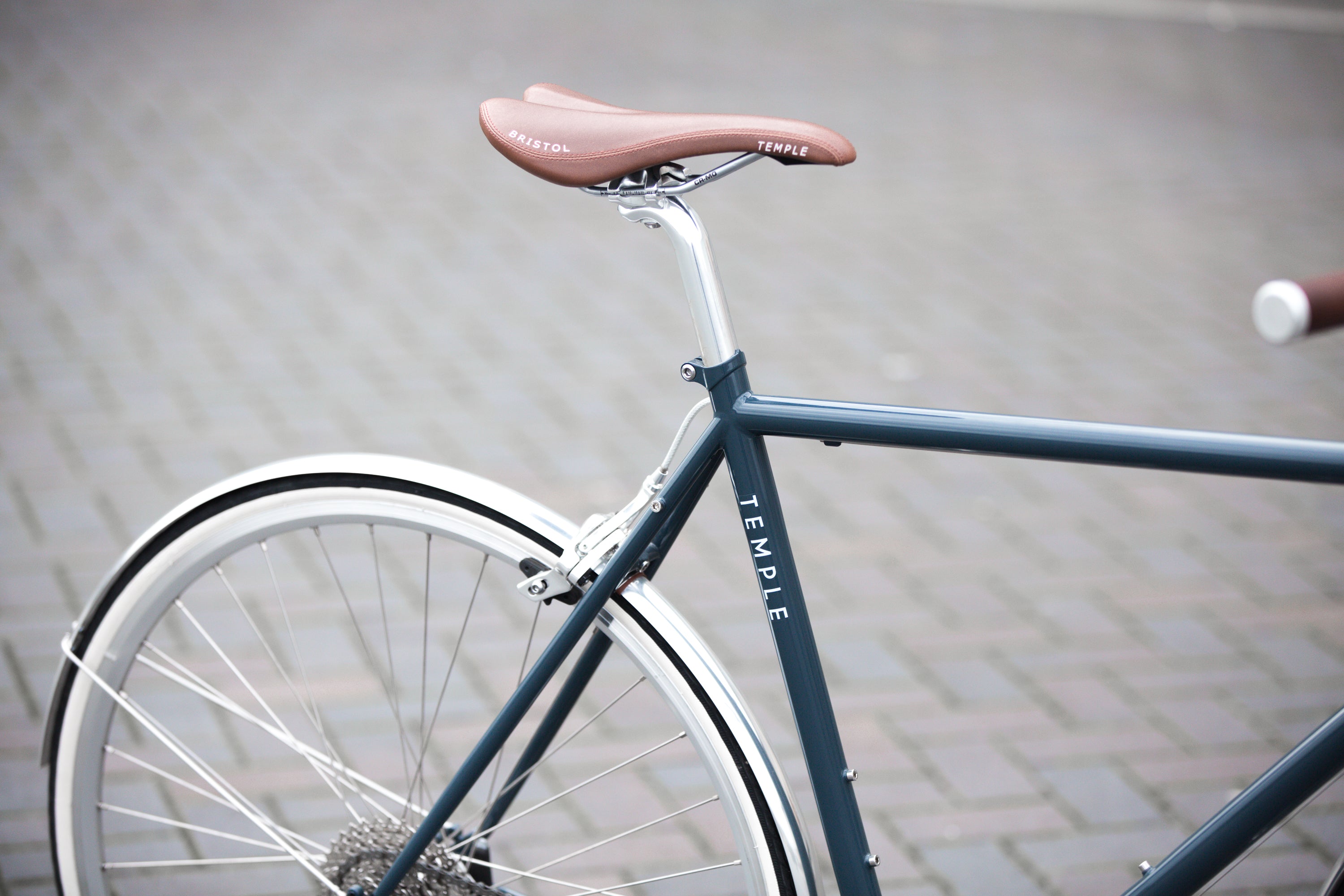 Rear wheel and leather saddle on a classic lightweight Temple steel, city bike.