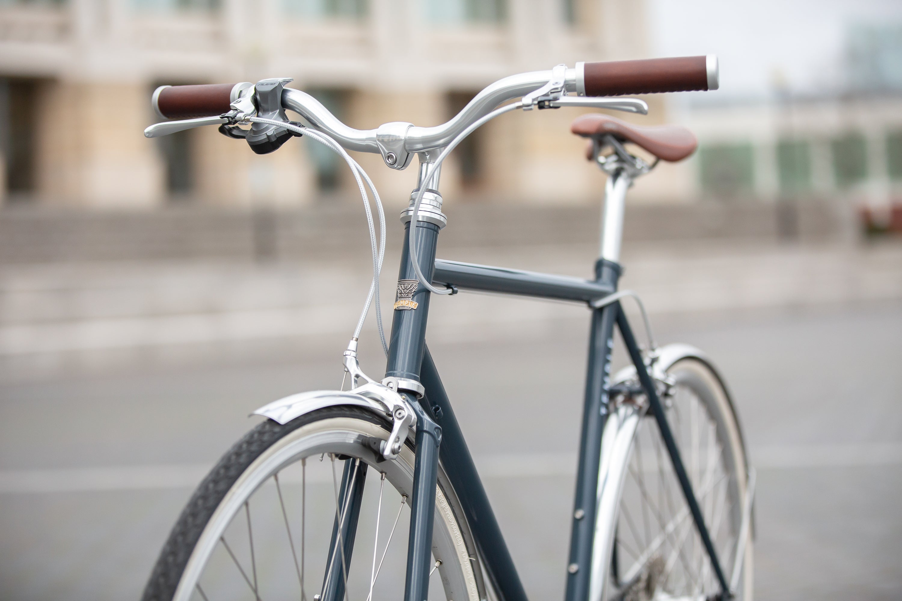 Front view of a classic lightweight steel bike in blue with Temple handlebars.