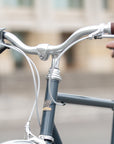 Silver braided brake cables and classic Temple handlebars on a blue daily commuter bike.