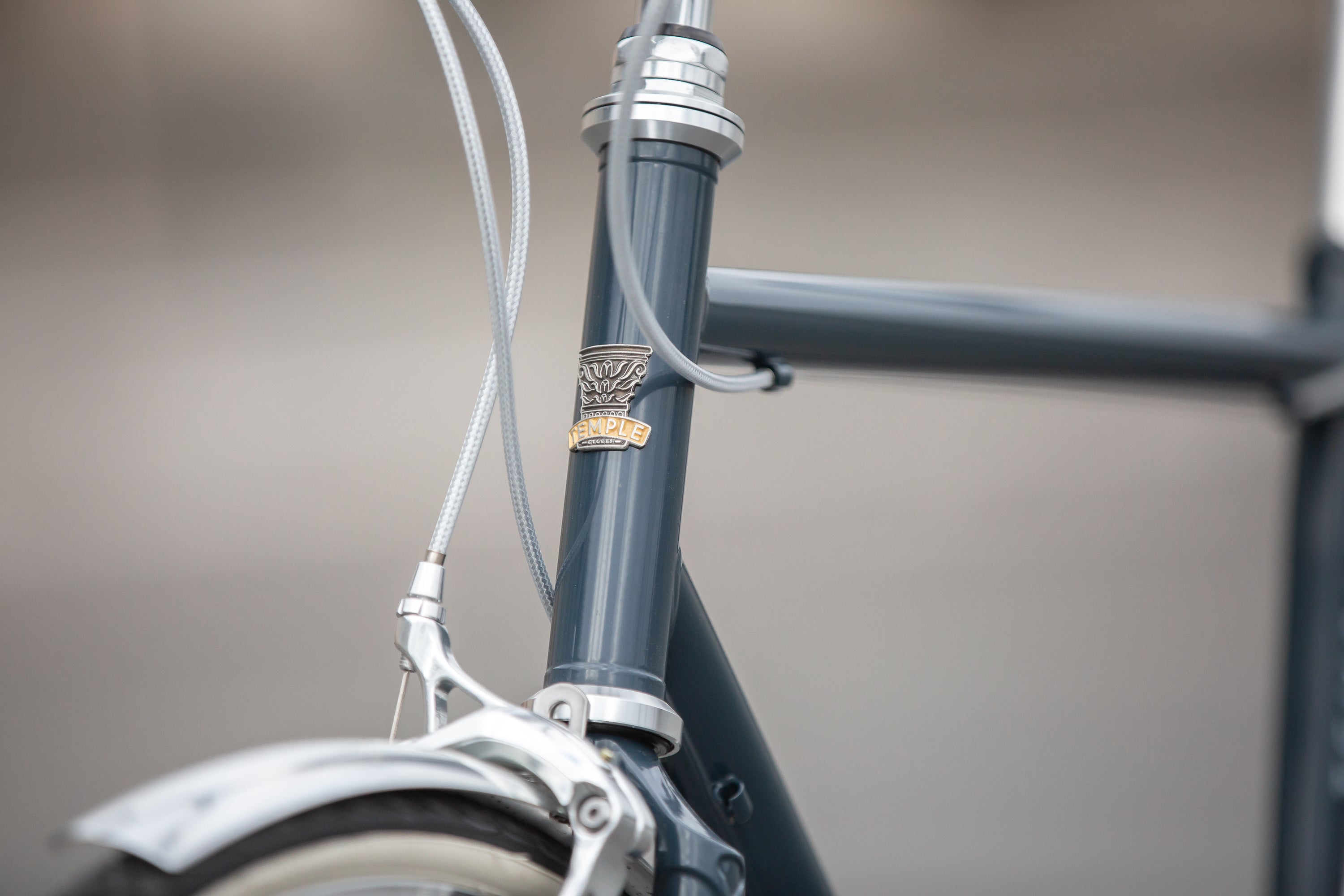 Temple head badge on blue steel head tube of a classic lightweight touring bike.