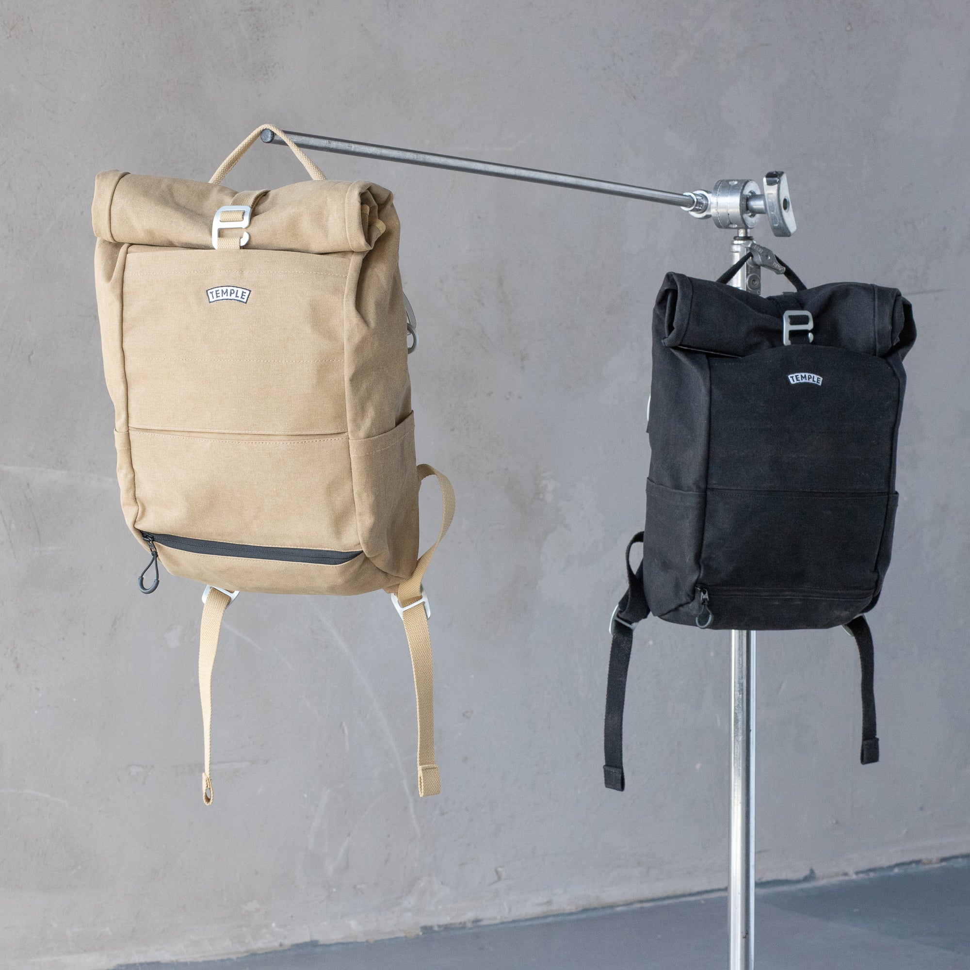 Two waterproof roll-top bike bags in an urban setting.