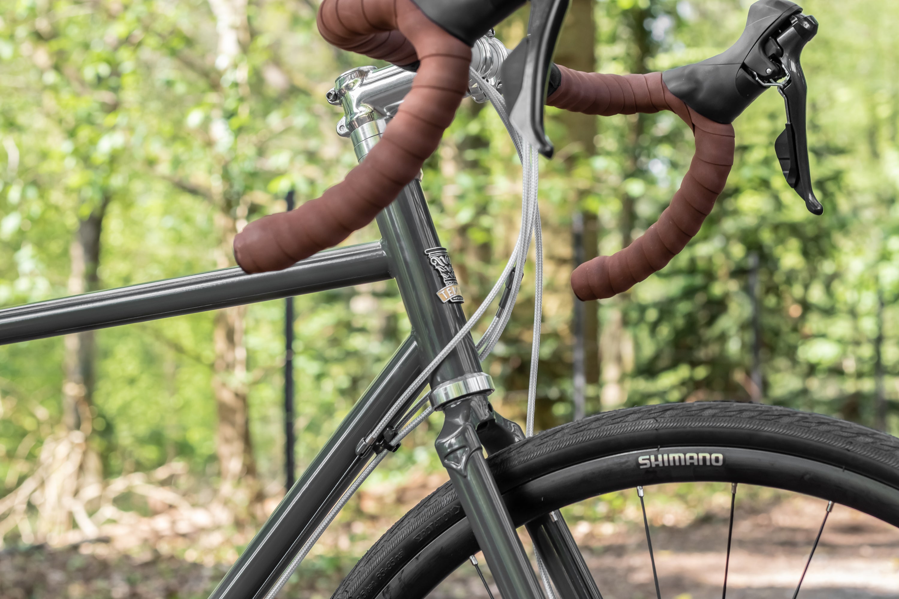 reynolds725, head tube and flared handlebars on a steel-framed adventure bike in racing-green.