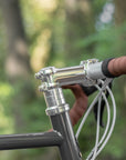 Silver braided brake cables and head tube on a steel adventure disc tour bike.