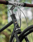 Racing green steel head tube and frame on a bikepacking gravel bike.