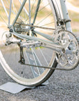 Shimano chain and gears on a green steel touring bike in a country setting.